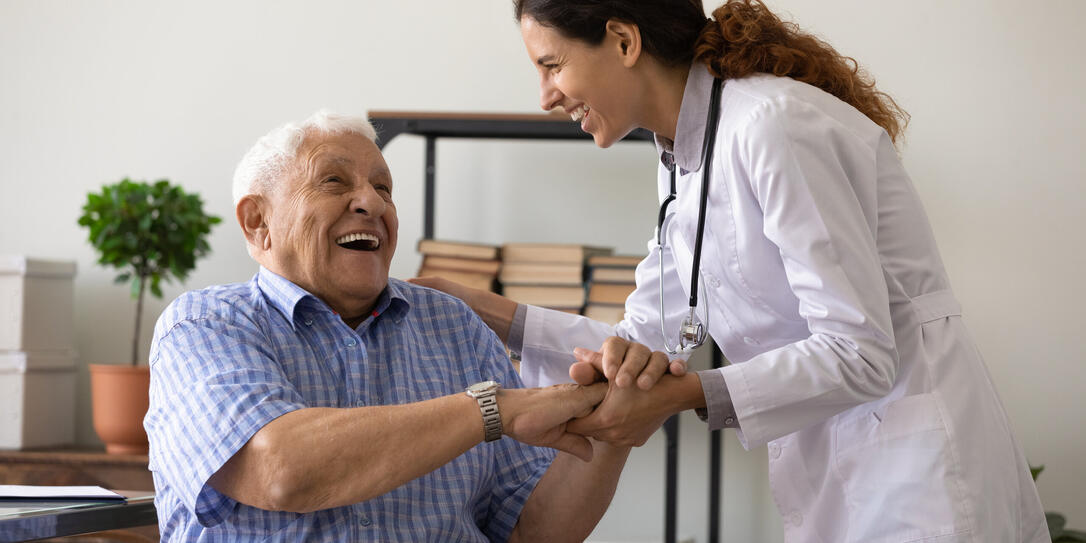 Caring female doctor support and cheer elderly man