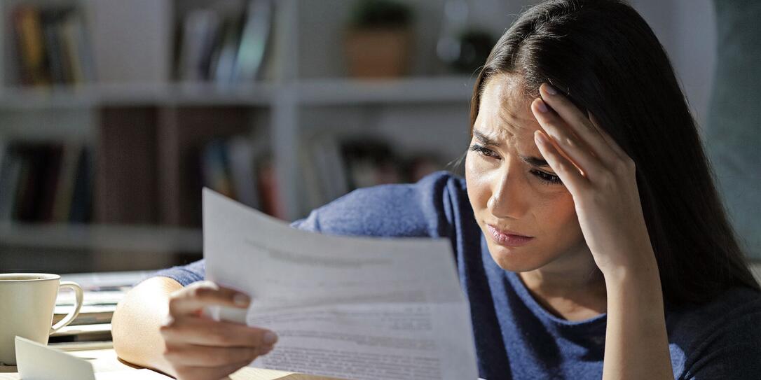 Worried girl reads bad news on letter at night at home Worried girl reads bad news on letter at night at home