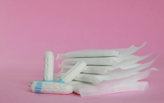 Menstrual pads and tampons on pink background