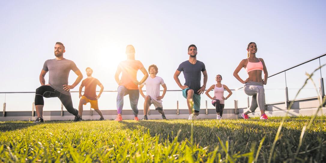 Below view of young athletic people having a sports training on a terrace. Below view of young athletic people having a sports training on a terrace.