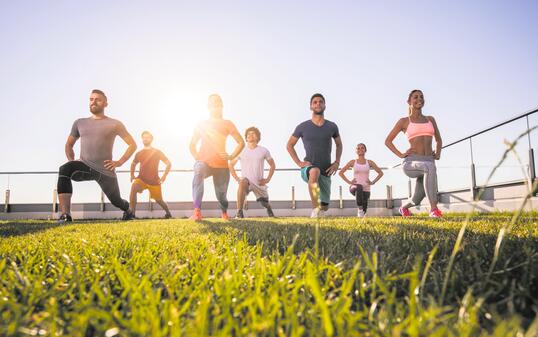 Below view of young athletic people having a sports training on a terrace.