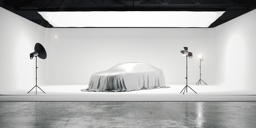 Large photographic studio with a car and several light sources. 3d rendering